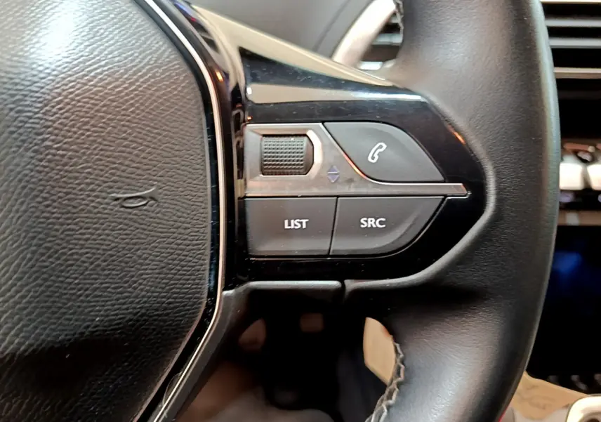 Gros plan sur les commandes gauche du volant cuir noir du Peugeot 3008 2019, boutons de gestion audio et appel.