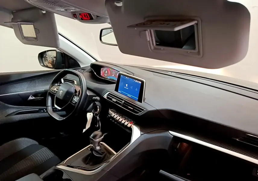 Intérieur Peugeot 3008 noir vu côté conducteur, tableau de bord moderne avec écran tactile et volant cuir multifonctions.