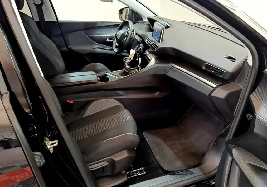 Intérieur avant droit du Peugeot 3008 noir 2019, montrant sièges tissu, tableau de bord avec écran tactile et volant cuir.