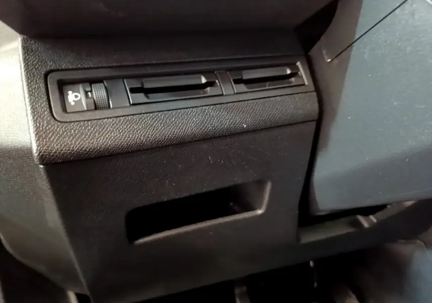 Détail du tableau de bord côté gauche du Peugeot 3008 noir, montrant la commande de réglage des phares et les aérateurs.