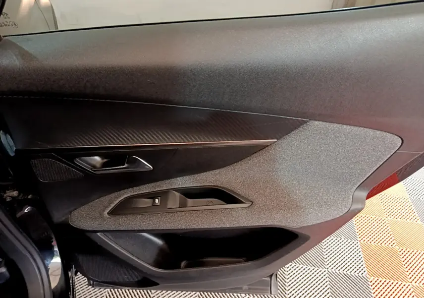 Vue rapprochée de la porte côté gauche du Peugeot 3008 noir, avec insert décoratif et commande de vitre électrique.