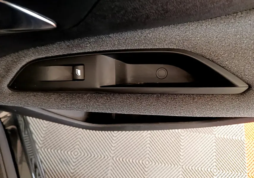 Détail de la commande de lève-vitre côté conducteur sur la porte intérieure d'un Peugeot 3008 noir de 2019.