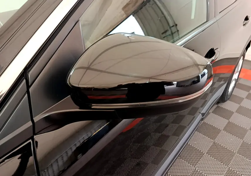 Rétroviseur côté gauche noir brillant du Peugeot 3008 2019, avec reflet de l'environnement intérieur.