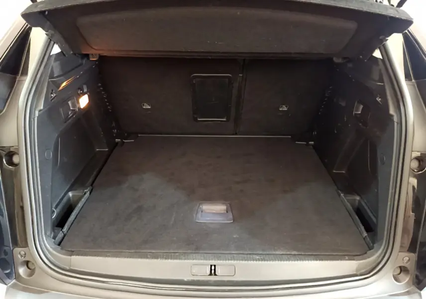 Coffre ouvert d'un Peugeot 3008 noir, vue de l'arrière montrant un espace de chargement propre et spacieux.