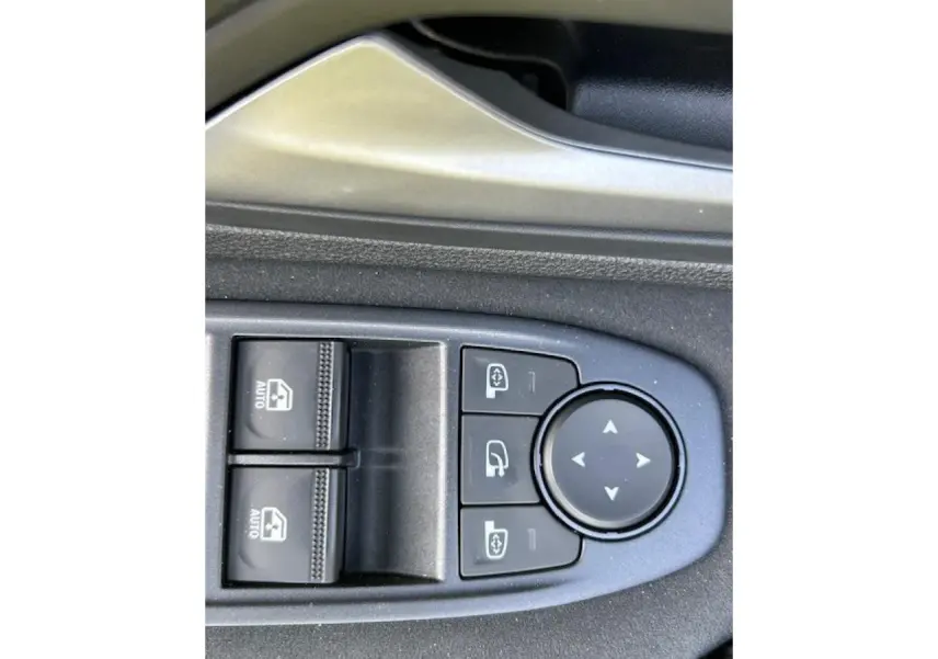 Gros plan sur les commandes électriques de réglage des rétroviseurs et lève-vitres côté conducteur du Dacia Duster kaki Dusty 2025.