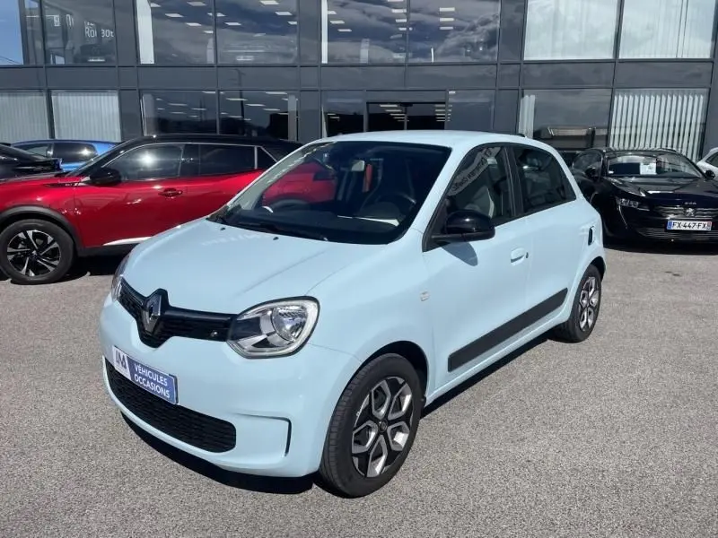 Renault Twingo III bleu dragée vue 3/4 avant droit, compacte avec jantes spécifiques et rétroviseurs noirs.