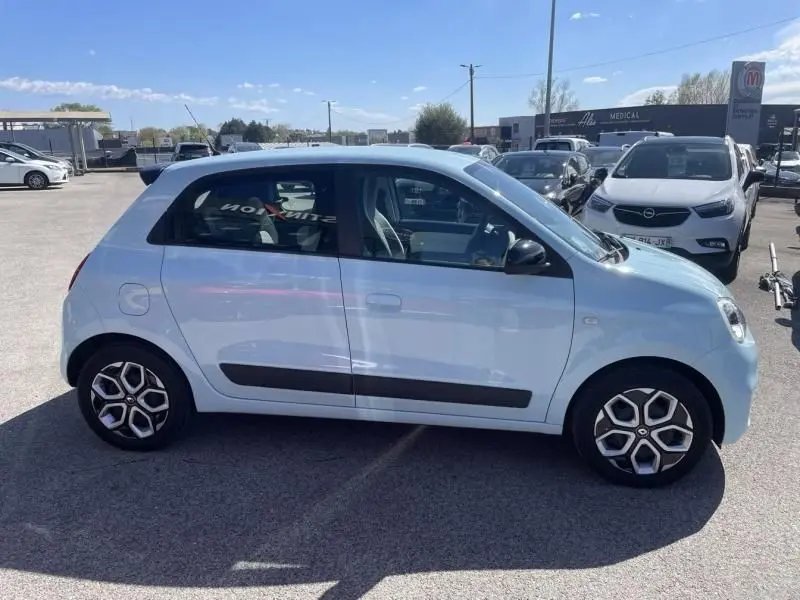 Profil côté gauche d'une Renault Twingo III bleu dragée 2022 avec jantes spécifiques et baguettes noires sur porte.