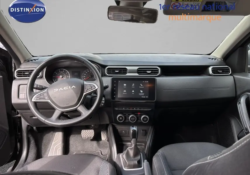 Vue intérieure avant du tableau de bord et volant noir du Dacia Duster Journey TCe 150 EDC 2024 avec écran tactile central.