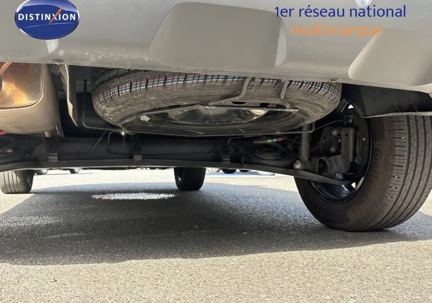 Vue en contre-plongée sous le Dacia Duster noir 2024, montrant la roue de secours et le train arrière.