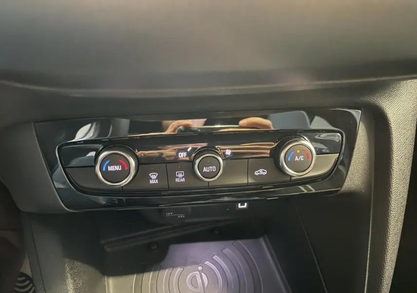 Détail de la console centrale noire de l’Opel Corsa blanche 2026 avec commandes de climatisation et chargeur induction.