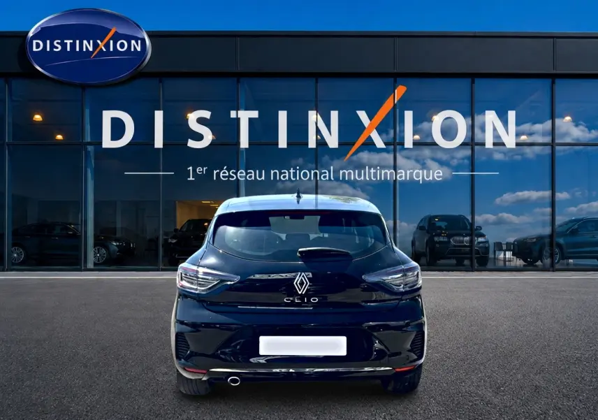 Vue arrière d'une Renault Clio V noire 2025, avec feux LED et sortie d'échappement chromée visible, devant un showroom Distinxion.
