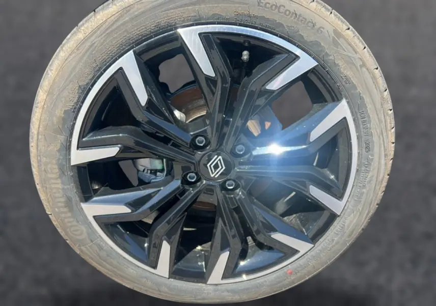 Gros plan sur une jante alliage noire et argentée avec logo Renault au centre, pneu Continental EcoContact 6 visible.