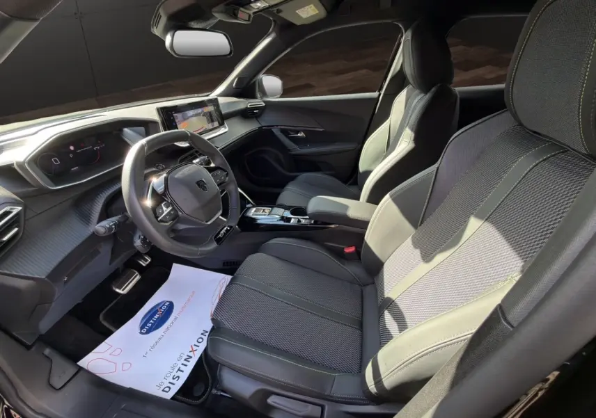 Vue intérieure côté conducteur du Peugeot 2008 Hybrid 145 e-DCS6 GT 2026 avec sièges cuir noirs et tableau de bord numérique.