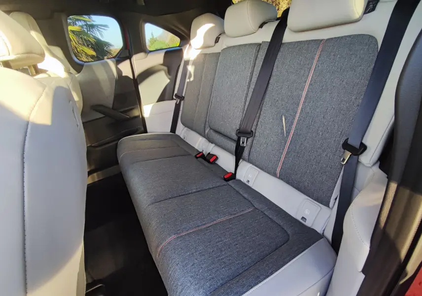 Vue intérieure arrière droite des sièges gris tissu avec surpiqûres rouges du Mazda MX-30 rouge métal 2023 e-SKYACTIV.