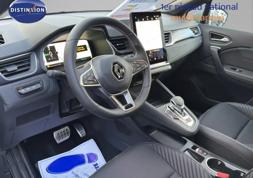 Vue intérieure côté conducteur du Renault Captur 2025 blanc nacré, volant multifonction et écran tactile vertical.