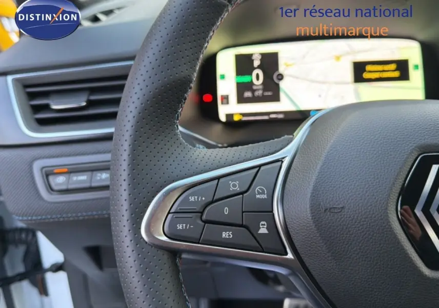 Gros plan sur le volant en cuir perforé et le tableau de bord numérique du Renault Captur blanc nacré 2025.