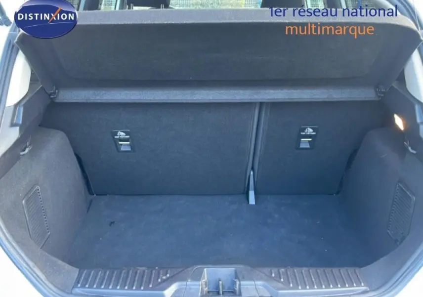 Coffre ouvert vu de l'arrière d'une Ford Fiesta blanche 2020, montrant un espace de chargement propre et vide.