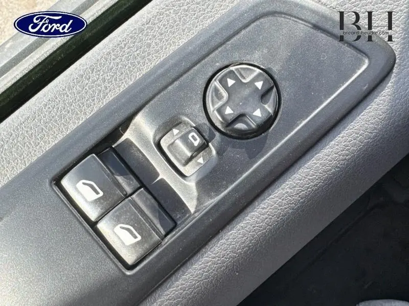 Gros plan sur les commandes de réglage des rétroviseurs et vitres côté conducteur d'un Peugeot Expert Fourgon blanc Banquise.