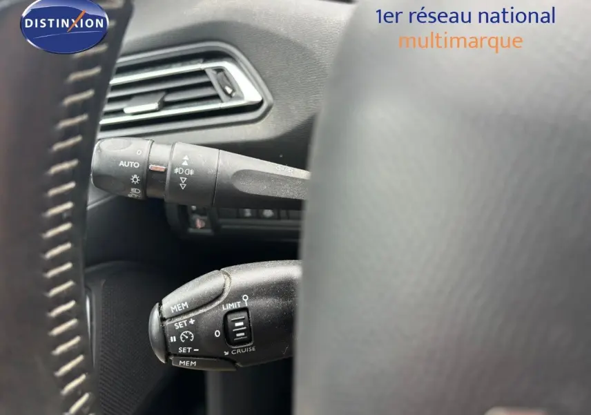 Gros plan sur les commandes de régulateur et feux au volant d'une Peugeot 308 Bleu Magnetic, version 2020.