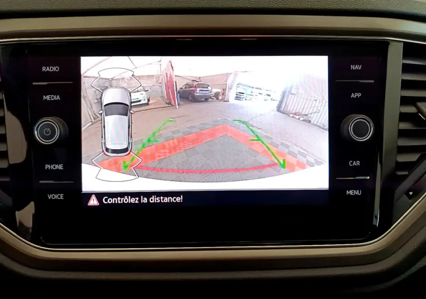 Écran tactile du Volkswagen T-Roc blanc montrant la caméra de recul avec guidage de trajectoire et avertissement de distance