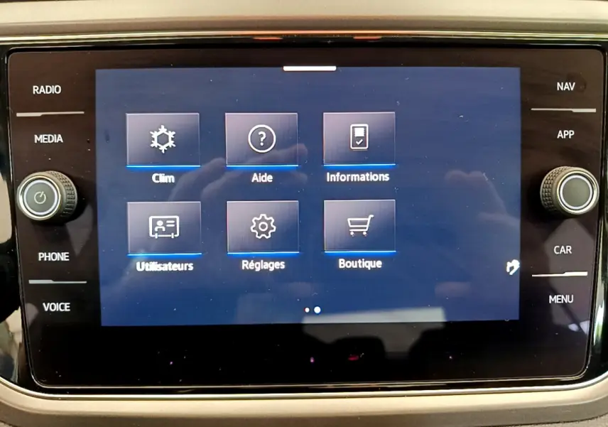 Écran tactile central du Volkswagen T-Roc 2021 affichant les options climatisation, aide, informations, utilisateurs, réglages et boutique.