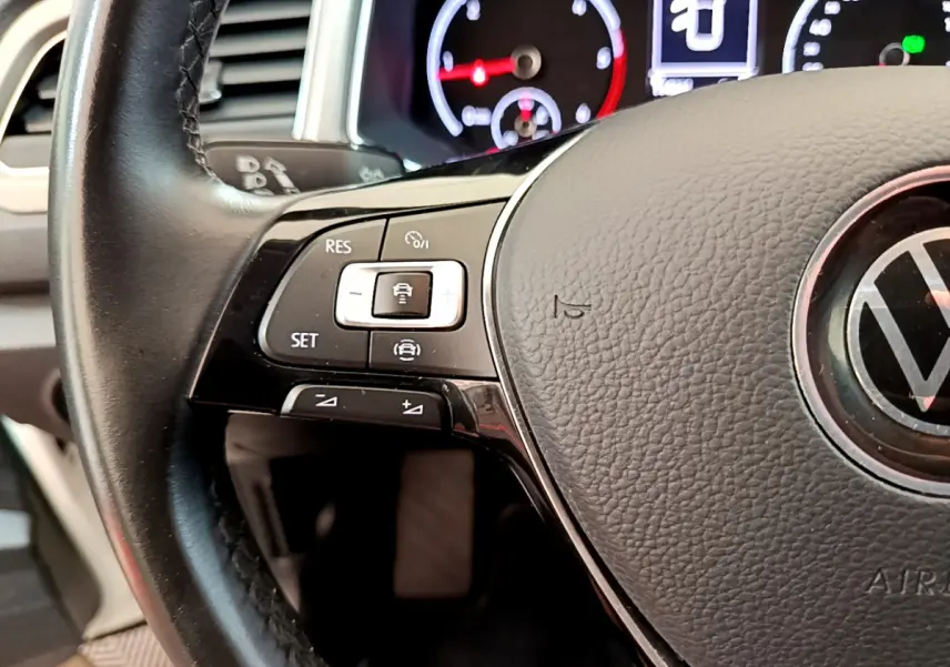 Gros plan sur le volant cuir multifonctions de la Volkswagen T-Roc 2021 avec commandes de régulateur de vitesse visibles.