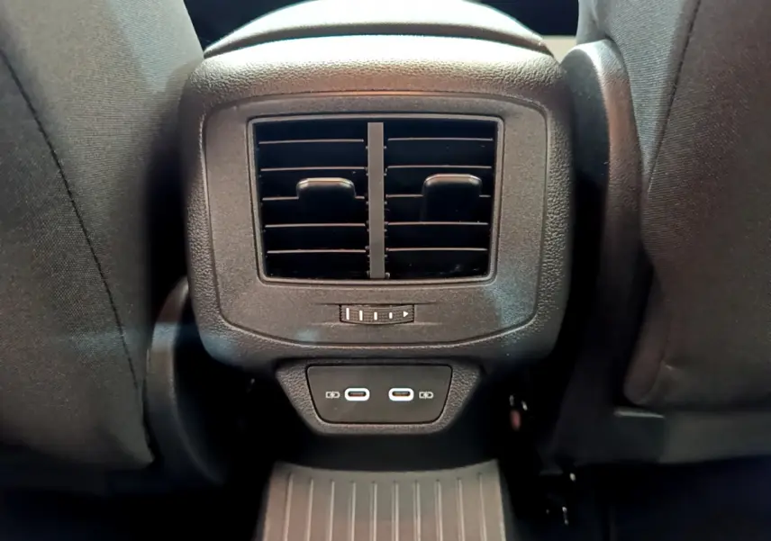 Gros plan sur la ventilation arrière et deux ports USB-C noirs entre les sièges avant du Volkswagen T-Roc blanc.