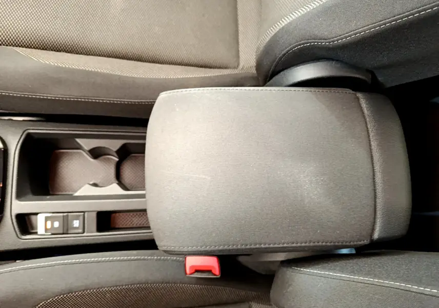 Accoudoir central en tissu gris avec porte-gobelets et bouton frein à main électrique dans Volkswagen T-Roc blanc 2021.