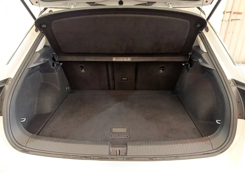 Coffre ouvert du Volkswagen T-Roc blanc 2021, vue arrière montrant l’espace de chargement et la tablette de séparation.