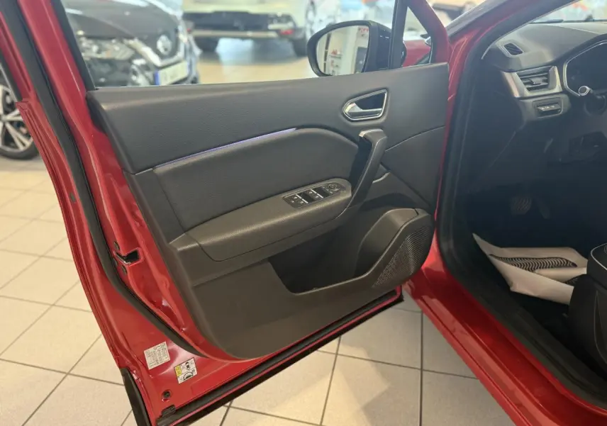 Vue intérieure de la porte avant gauche rouge foncé du Renault Captur 2020 avec commandes de vitres et rétroviseur.
