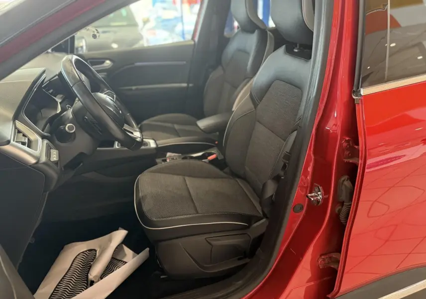 Vue intérieure côté conducteur du Renault Captur rouge foncé 2020, sièges tissu et cuir noirs visibles.