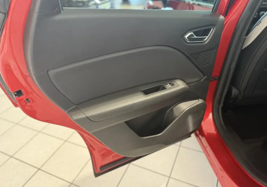 Porte arrière gauche ouverte du Renault Captur rouge foncé 2020, montrant la garniture intérieure noire et les commandes de fenêtre.