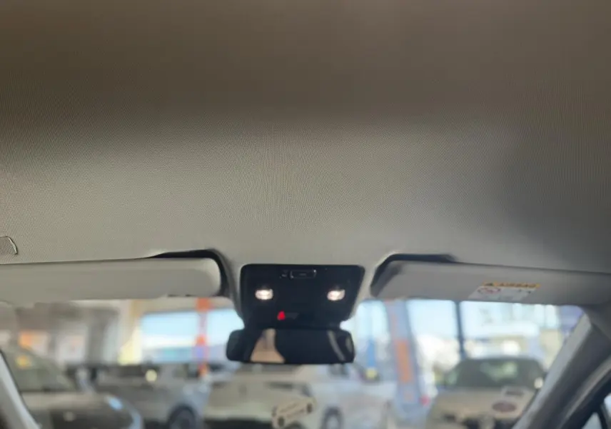 Vue intérieure du toit ouvrant électrique avec pare-soleil et éclairage, sur Renault Captur rouge foncé 2020 Intens.