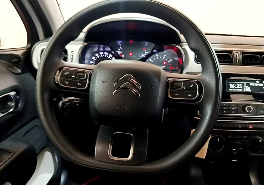 Vue rapprochée du volant noir de la Citroën C3 PureTech 68 BVM Live avec tableau de bord et console centrale visibles.