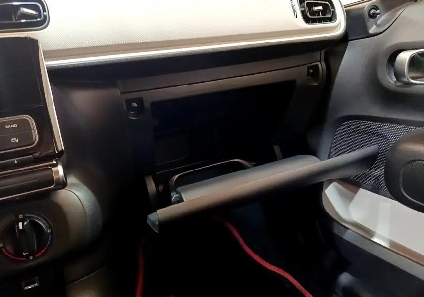 Intérieur de la Citroën C3 blanc 2018, vue côté passager avec boîte à gants ouverte et tableau de bord clair.