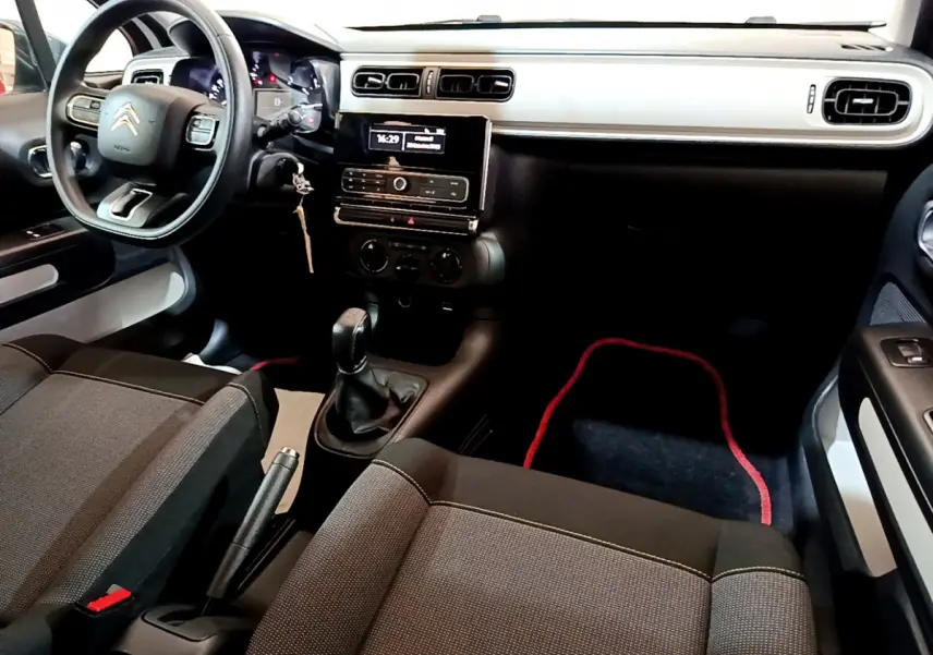 Vue intérieure avant droite du tableau de bord et des sièges noirs de la Citroën C3 PureTech 68 BVM Live 2018.