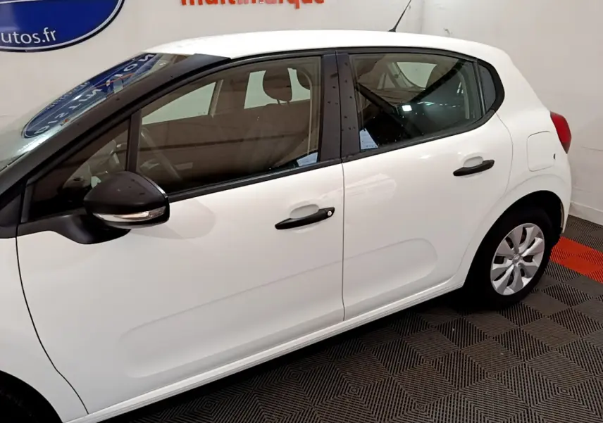 Vue latérale droite d'une Citroën C3 blanche de 2018, avec poignées et rétroviseurs noirs contrastants.