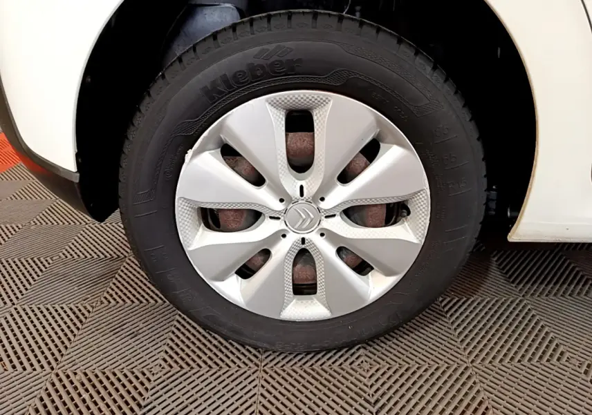 Gros plan sur la roue avant gauche d'une Citroën C3 blanche avec enjoliveur au design moderne.