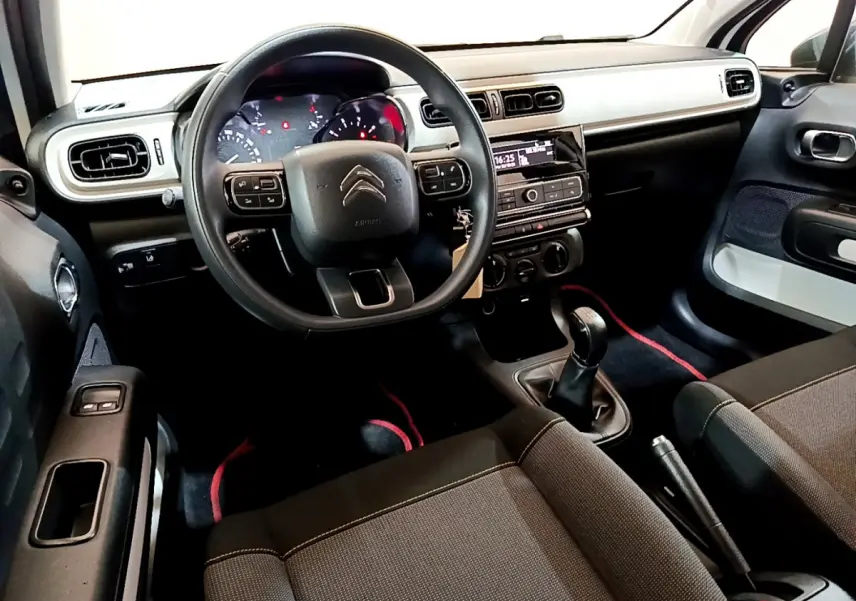 Intérieur avant de la Citroën C3 PureTech 68 BVM Live 2018, vue côté conducteur, tableau de bord clair et sièges noirs.