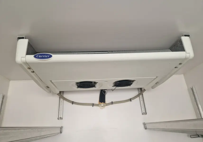 Vue intérieure du groupe frigorifique Carrier blanc fixé au plafond de la cellule isotherme du Renault Master Plancher Cabine blanc.