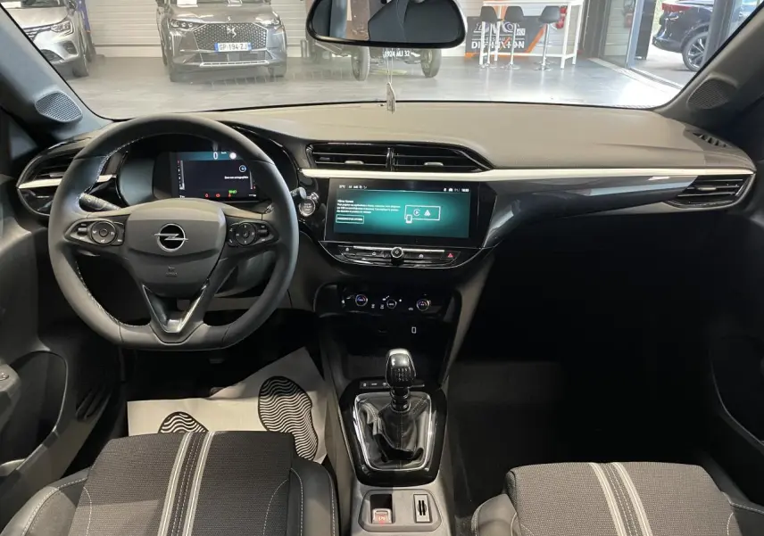 Vue intérieure avant de l'Opel Corsa gris, avec volant cuir, écran tactile 10 pouces et boîte manuelle.