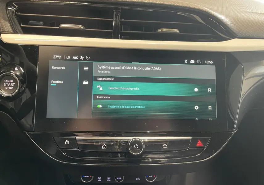 Vue rapprochée de l’écran tactile central noir de l’Opel Corsa gris, affichant les aides à la conduite avancées.