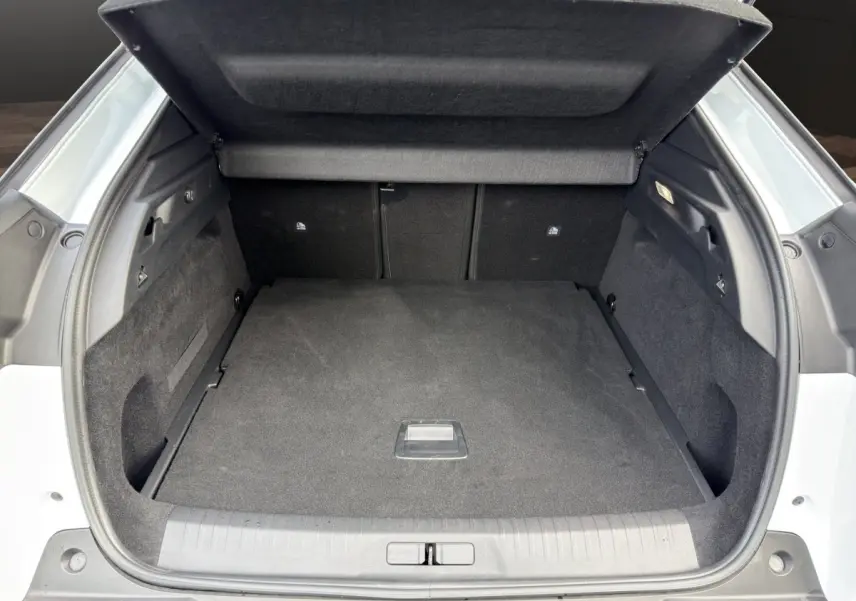 Coffre ouvert du Peugeot 3008 blanc, vue arrière montrant l'espace de chargement et la tablette cache-bagages.