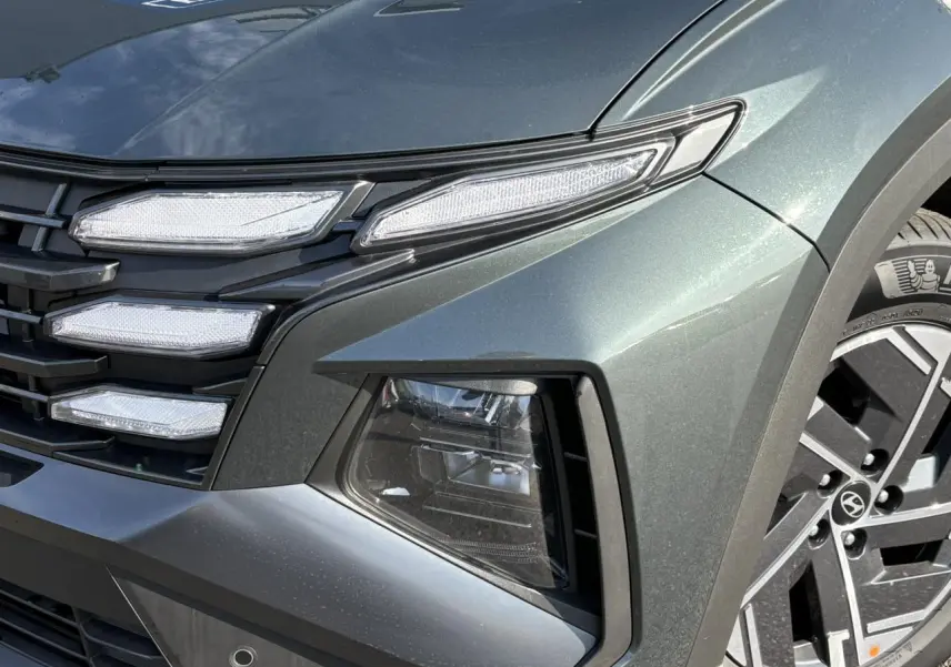Gros plan sur l'avant droit du Hyundai Tucson Cypress Green, mettant en valeur ses phares LED et jante alliage 17 pouces.