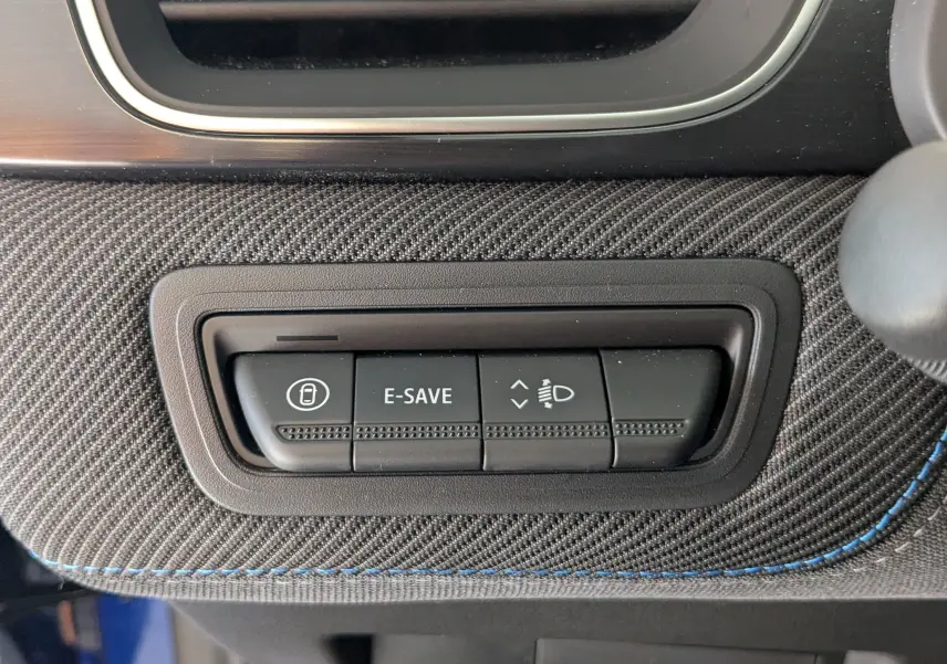 Gros plan sur les boutons de commande E-SAVE et réglage des phares, sur la console intérieure du Renault Symbioz bleu iron.