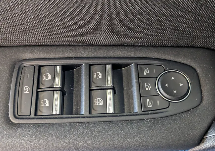 Panneau de commandes des vitres électriques et rétroviseurs sur la porte intérieure d'une Renault Symbioz bleu Iron.