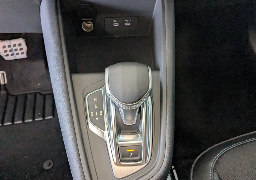 Le levier de vitesses automatique vu de dessus dans l'habitacle noir du Renault Symbioz bleu Iron hybride 2025.