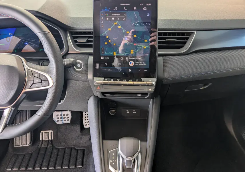 Intérieur du Renault SYMBIOZ E-TECH 2025, vue centrale sur la console avec écran tactile vertical et levier de vitesse automatique.