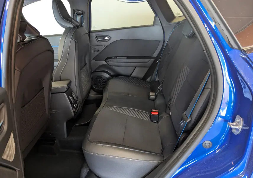 Vue intérieure côté droit sur la banquette arrière noire avec surpiqûres bleues du Renault Symbioz E-Tech Full Hybrid 2025 bleu Iron.