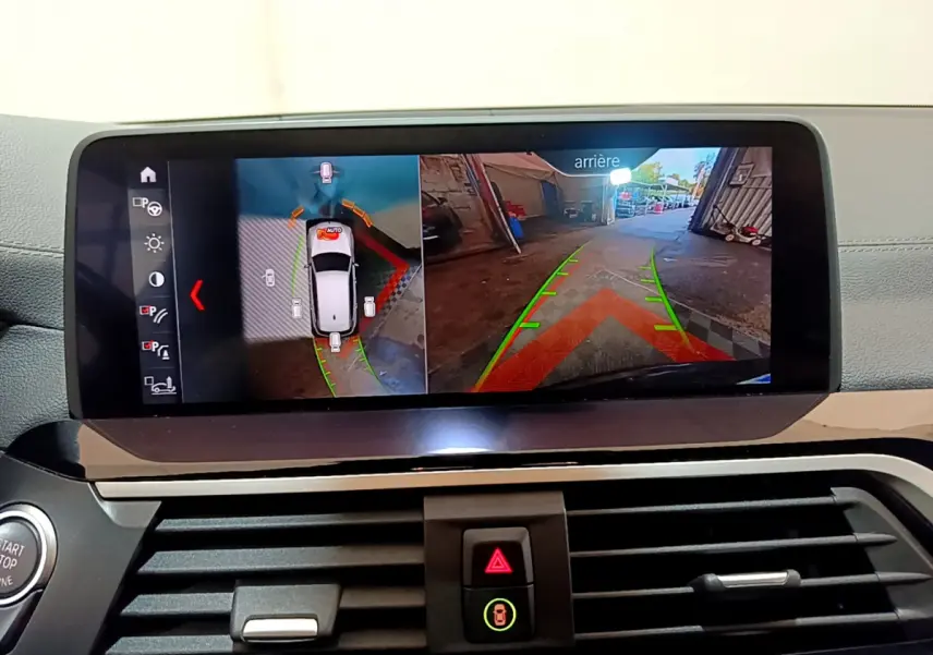 Écran tactile intérieur montrant la caméra de recul et la vue 360° du BMW X3 noir en stationnement.